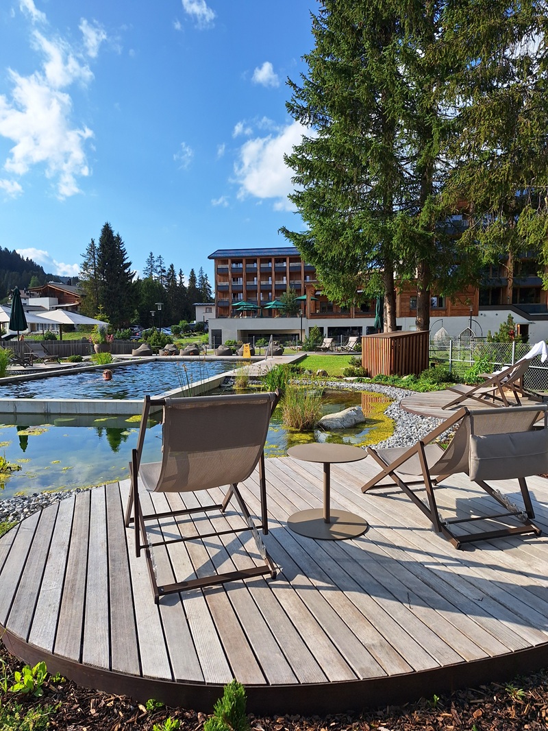 Valbella Resort, Lenzerheide: Blick über den Badeteich Richtung Tgiasa Principala, vom Trubel auf dem Minigolf- bzw. Tennisplatz direkt daneben merkt man dort nichts.